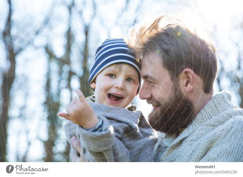Glücklicher Vater trägt Sohn im Park glücklich glücklich sein glücklichsein Parkanlagen Parks Papas Väter Vati Vatis Papis Söhne tragen transportieren Eltern