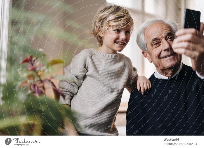 Glücklicher Großvater und Enkel machen ein Selfie zu Hause Leute Menschen People Person Personen Europäisch Kaukasier kaukasisch 2 2 Menschen 2 Personen zwei
