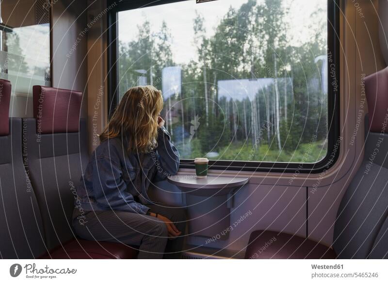 Frau reist mit dem Zug und schaut aus dem Fenster reisen verreisen schauen sehend weiblich Frauen Bahnen Züge Erwachsener erwachsen Mensch Menschen Leute People