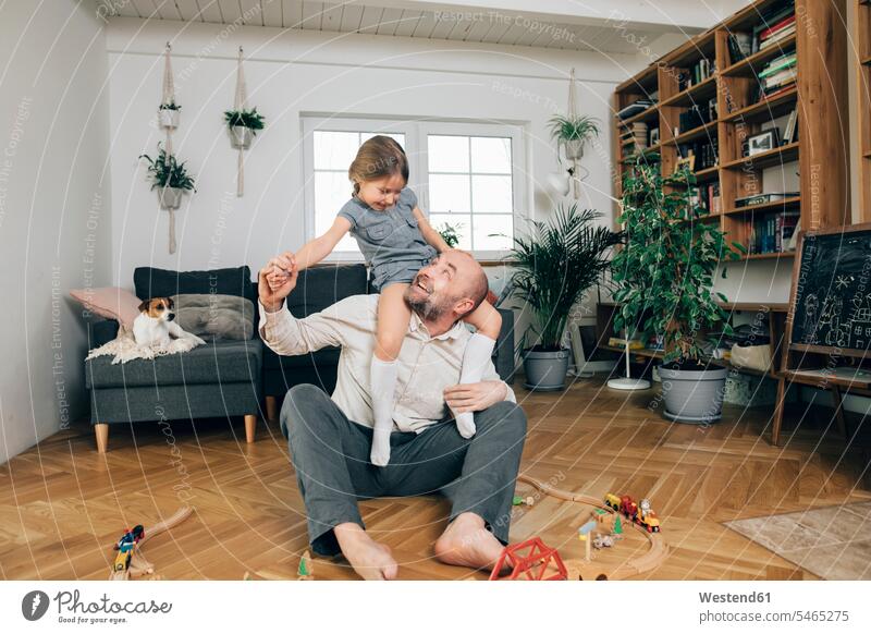 Vater spielt mit seiner Tochter zu Hause Tiere Tierwelt Haustiere Hunde Couch Couches Liege Sofas sitzend sitzt freuen Frohsinn Fröhlichkeit Heiterkeit daheim
