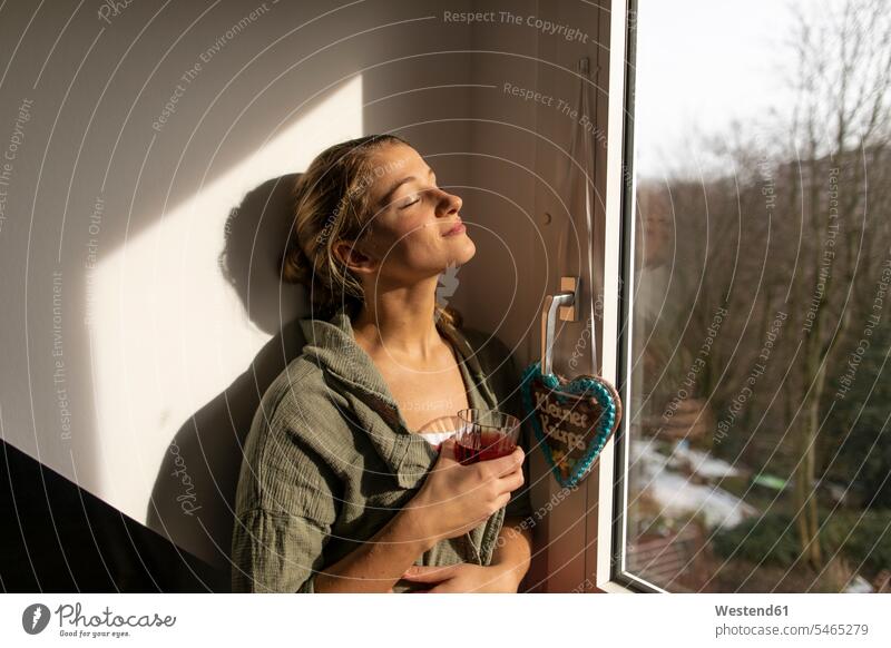 Junge Frau am Fenster genießt den Sonnenschein Single Alleinstehende Unverheirateter Singles Alleinstehender Lifestyle Lebensstil Zuversicht Zuversichtlich