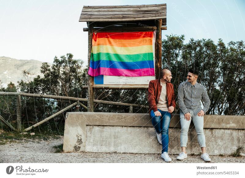 Homosexuelles Paar mit Homosexuell Stolz Flagge auf einer Reise in den Bergen Leute Menschen People Person Personen Europäisch Kaukasier kaukasisch 2 2 Menschen