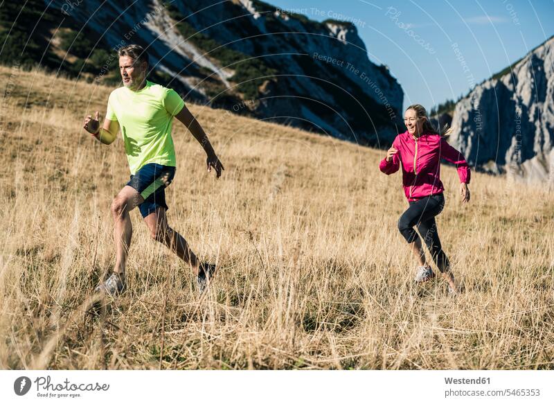 Österreich, Tirol, Paar beim Laufen in den Bergen Gebirge Berglandschaft Gebirgslandschaft Gebirgskette Gebirgszug laufen rennen Pärchen Paare Partnerschaft