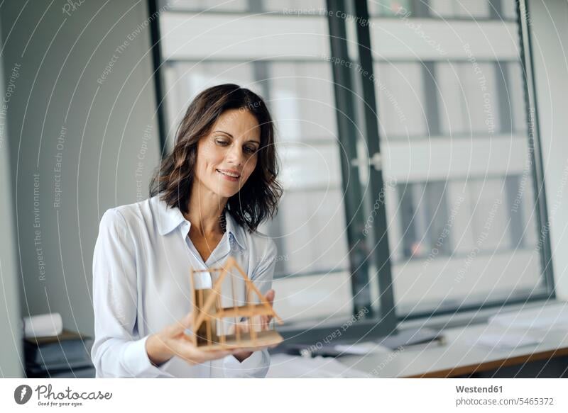 Geschäftsfrau hält Architekturmodell eines Hauses Büro Office Büros Architektin Architektinnen halten Geschäftsfrauen Businesswomen Businessfrauen Businesswoman