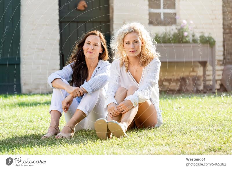 Zwei Frauen sitzen im Garten auf Gras im Sonnenschein Freundinnen Zusammenhalt Verbundenheit Zusammengehörigkeit Bindung sich verstehen Gemeinschaft Zuversicht