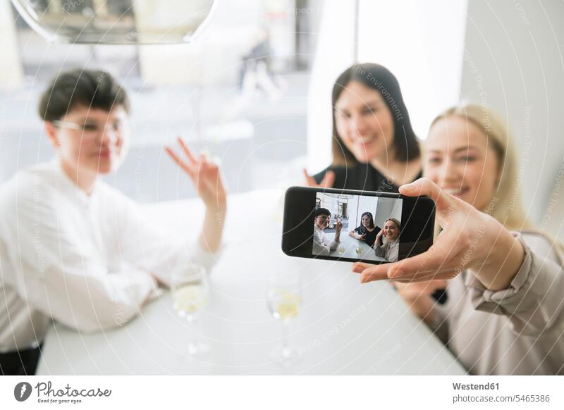 Glückliche Freunde machen ein Selfie in einem Restaurant Hand Hände Motiv Motive Handzeichen Zeichen Pose posieren Gemeinsamkeit zusammen gemeinsam