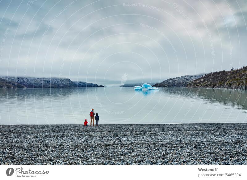 Chile, Torres del Paine Nationalpark, Lago Grey, Frau mit zwei Söhnen steht am Ufer und schaut auf Eisberg Seeufer Sohn Seen Junge Buben Knabe Jungen Knaben
