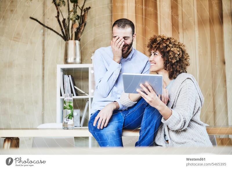 Glücklicher Mann und Frau teilen Tablette in modernen Büro Kollegen Arbeitskollegen Tablet Computer Tablet-PC Tablet PC iPad Tablet-Computer Office Büros Teilen