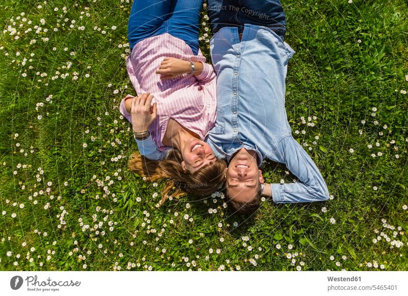 Glückliches junges Paar entspannt auf Gras in einem Park, Blick von oben Toskana ausruhen Rast Erholung erholen offenes Lächeln lachen offenes Laecheln Auszeit