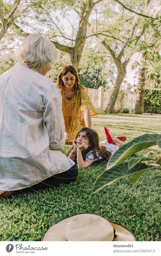 Mehrgenerationen-Familie entspannt auf Grasland im Hof Farbaufnahme Farbe Farbfoto Farbphoto Spanien Freizeitbeschäftigung Muße Zeit Zeit haben Freizeitkleidung