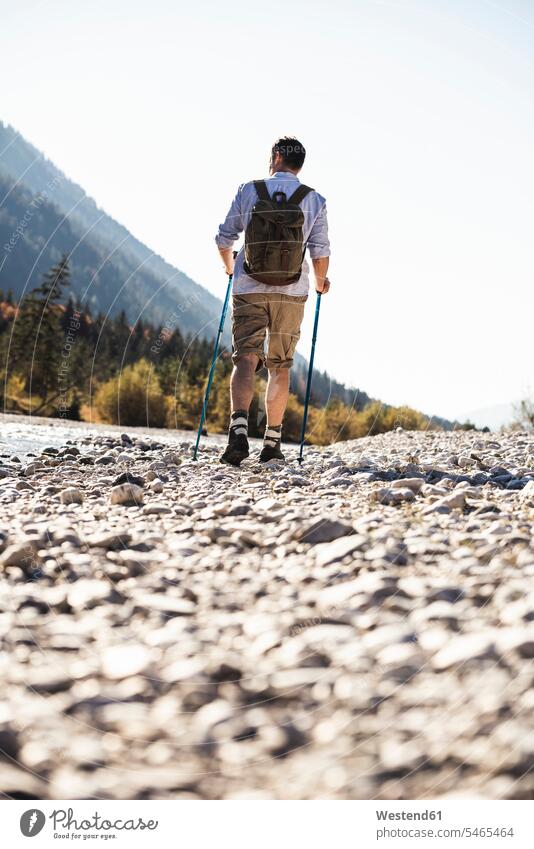 Österreich, Alpen, Mann beim Wandern auf Kieselsteinen entlang eines Baches Europäer Europäisch Kaukasier kaukasisch reifer Mann reife Männer 45-50 Jahre