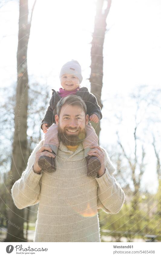 Porträt eines glücklichen Vaters, der seine Tochter im Park auf den Schultern trägt Glück glücklich sein glücklichsein tragen transportieren Portrait Porträts