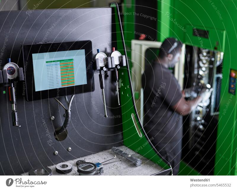 Mann arbeitet an einer Maschine Afroamerikanisch Afro-Amerikanisch Afroamerikaner Afro-Amerikaner CNC Kontrolle kontrollieren Maschinen überprüfen testen