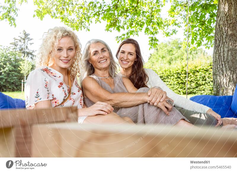 Frauen einer Familie, die Spaß im Garten hat, auf einem Schaukelbett sitzend Deutschland drei Personen drei Menschen 3 3 Personen 3 Menschen reife Frau