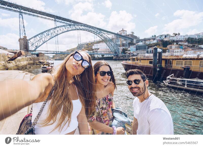 Fröhliche junge Freunde machen ein Selfie mit dem Fluss Douro in der Stadt Porto, Portugal Außenaufnahme außen draußen im Freien Farbaufnahme Farbe Farbfoto