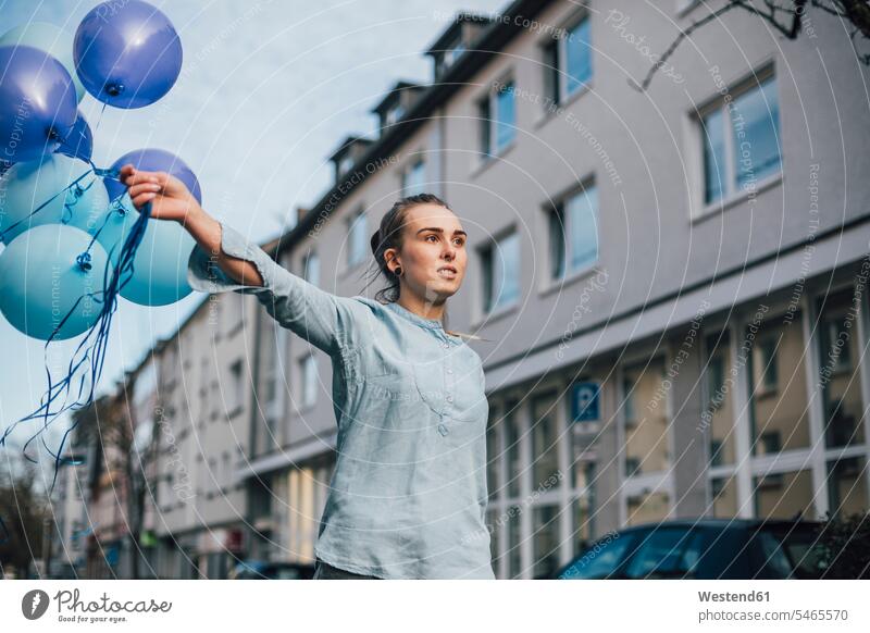Porträt einer jungen Frau mit blauen Luftballons im Freien Ballon Ballons Luftballone blauer blaues weiblich Frauen Dekoration dekorieren Dekorationen Farbe