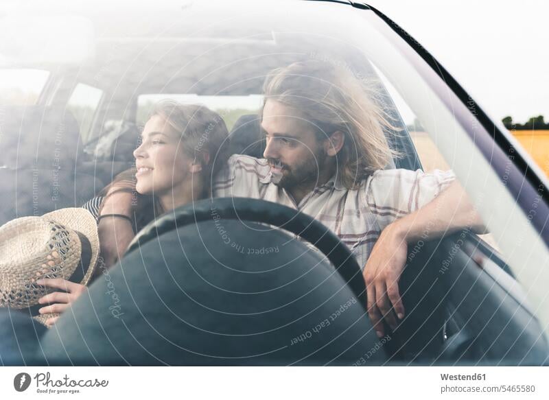 Zärtliches junges Paar in einem Auto Wagen PKWs Automobil Autos Zuneigung Pärchen Paare Partnerschaft Kraftfahrzeug Verkehrsmittel KFZ Mensch Menschen Leute