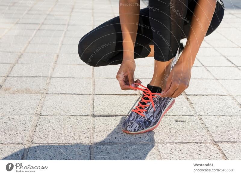 Nahaufnahme einer jungen Frau, die ihre Schuhe vor dem Training bindet Workout binden weiblich Frauen Erwachsener erwachsen Mensch Menschen Leute People