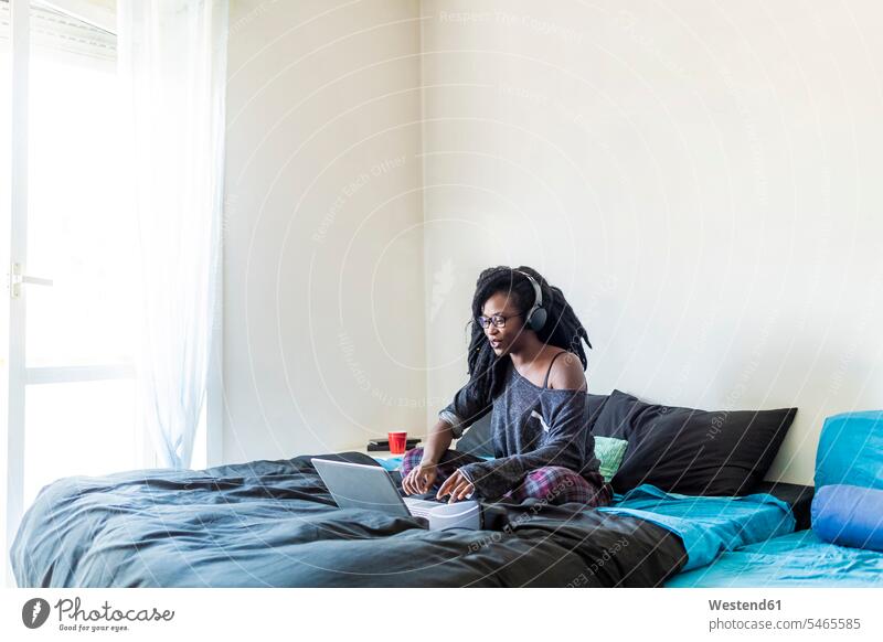 Junge Frau benutzt Laptop zu Hause am Bett Technik Technologien Leute Menschen People Person Personen 1 Ein ein Mensch eine nur eine Person single erwachsen