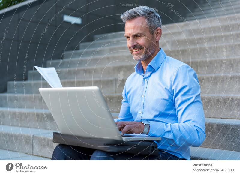 Porträt eines Geschäftsmannes, der mit einem Laptop auf einer Treppe sitzt benutzen benützen Portrait Porträts Portraits Notebook Laptops Notebooks Businessmann