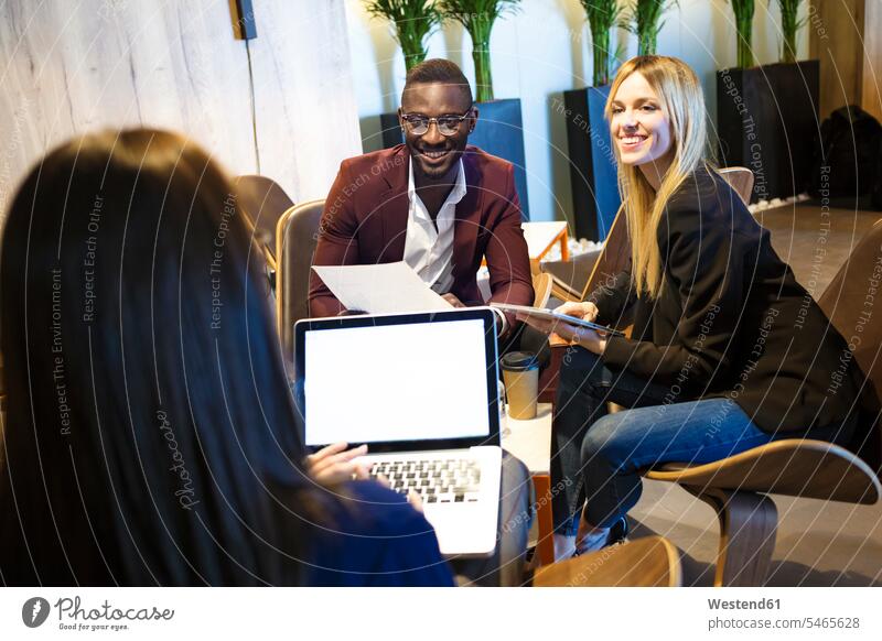 Geschäftsleute, die in einer Hotellobby sitzen und zusammenarbeiten Geschäftspartner Geschäftsfreund Geschäftsfreunde Laptop benutzen Laptop benützen Tablet