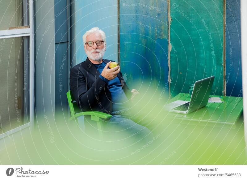 Porträt eines älteren Mannes, der mit einem Laptop im Freien sitzt und eine Pause macht Leute Menschen People Person Personen Europäisch Kaukasier kaukasisch 1