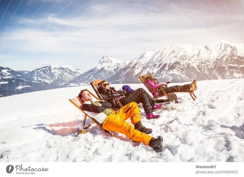 Freunde sonnen sich im Winter in Liegestühlen in der Berglandschaft, Achenkirch, Österreich Touristen Stuehle Stühle sich sonnen sonnenbaden Jahreszeiten