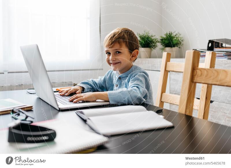 Kleiner Junge sitzt im Büro seines Vaters, mit Laptop benutzen benützen Schreibtisch Arbeitstisch Schreibtische Notebook Laptops Notebooks arbeiten sitzen