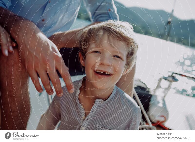 Lächelnder Junge mit Eltern auf einem Segelboot Segelboote Segelschiff Buben Knabe Jungen Knaben männlich Segeln segelnd segelt Portrait Porträts Portraits