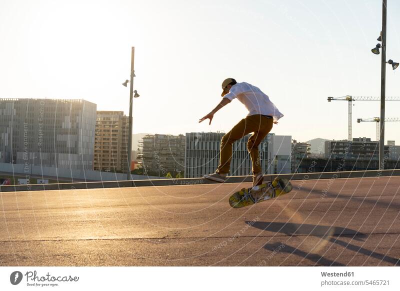 Junger Mann fährt Skateboard in der Stadt Skateboarder Skateboardfahrer Skateboarders Skater staedtisch städtisch Rollbretter Skateboards fahren Männer männlich