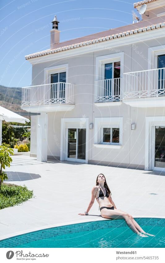 Junge Frau genießt die Sommerzeit am Pool Bikinis entspannen relaxen sich sonnen sonnenbaden sommerlich freuen geniessen Genuss zufrieden türkisfarben frei Muße