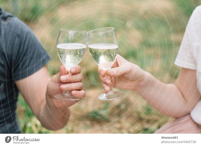 Junges Paar trinkt in den Weinbergen mit Prosecco, Nahaufnahme auf dem Land auf dem Lande Muße Miteinander Zusammen Bindung Gemeinschaft Verbundenheit Essen