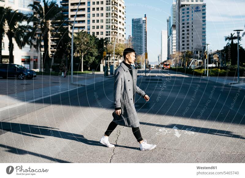 Spanien, Barcelona, junger Mann beim Überqueren der Straße Strassen Straßen überqueren Männer männlich Erwachsener erwachsen Mensch Menschen Leute People