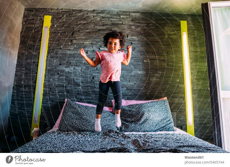 Verspieltes Mädchen springt zu Hause auf dem Bett Farbaufnahme Farbe Farbfoto Farbphoto Freizeitbeschäftigung Muße Zeit Zeit haben Freizeitkleidung