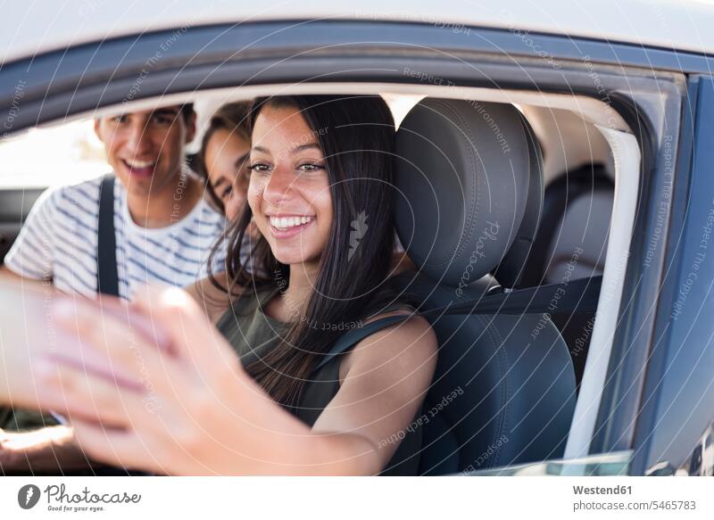 Freunde haben Spaß auf einem Roadtrip und machen Smartphone-Selfies Auto Wagen PKWs Automobil Autos Ausflug Ausflüge Kurzurlaub Ausfluege Spass Späße spassig