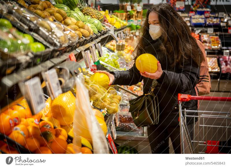 Ältere Frau kauft Obst im Supermarkt während COVID-19 Farbaufnahme Farbe Farbfoto Farbphoto Innenaufnahme Innenaufnahmen innen drinnen Tag Tageslichtaufnahme