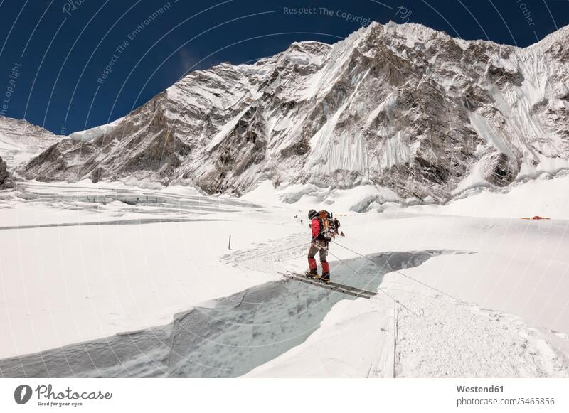 Nepal, Solo Khumbu, Everest, Sagamartha-Nationalpark, Bergsteiger, der den Eisfall auf einer Leiter überquert gehen gehend geht Everest Region Everest-Region