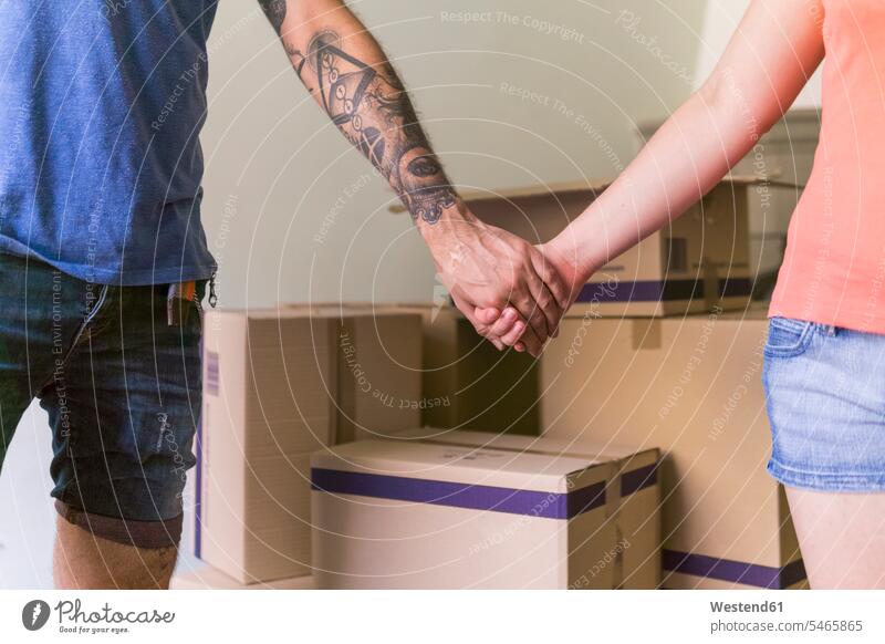 Händchenhaltendes Paar im neuen Zuhause, Teilansicht Hand Hände Pärchen Paare Partnerschaft Mensch Menschen Leute People Personen erwartungsvoll Erwartung