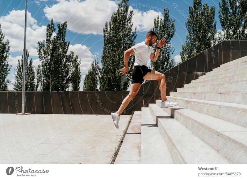 Männlicher Athlet rennt die Treppe hinauf T-Shirts rennen Farben Farbtoene Farbton Farbtöne weiss weiße weißer weißes fit gesund Gesundheit Jogging Muße Anreiz
