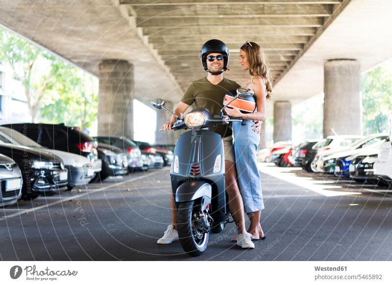 Glückliches Paar mit Motorroller an Unterführung glücklich glücklich sein glücklichsein Pärchen Paare Partnerschaft Unterführungen Strassenunterfuehrung