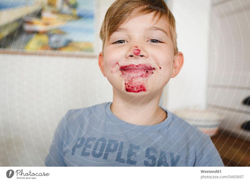 Porträt eines grinsenden Jungen mit Blaubeermarmelade im Gesicht Koepfe Köpfe Gesichter T-Shirts freuen geniessen Genuss Glück glücklich sein glücklichsein