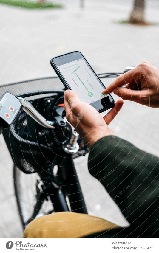 Nahaufnahme eines Mannes mit E-Bike, der ein Smartphone-Navigationssystem benutzt Fahrrad Bikes Fahrräder Räder Rad Handy Mobiltelefon Handies Handys