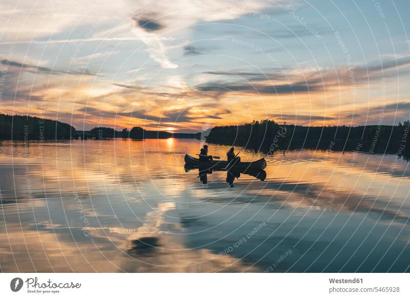 Junge Leute beim Bootfahren auf dem See bei Sonnenuntergang Menschen People Person Personen Europäisch Kaukasier kaukasisch 2 2 Menschen 2 Personen zwei
