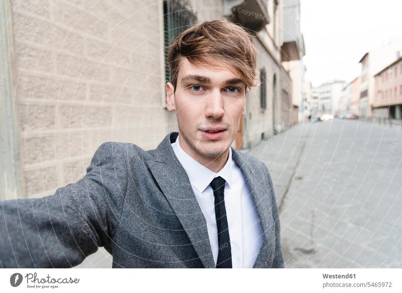 Porträt eines jungen Geschäftsmannes, der ein Selfie in der Stadt macht geschäftlich Geschäftsleben Geschäftswelt Geschäftsperson Geschäftspersonen Businessmann