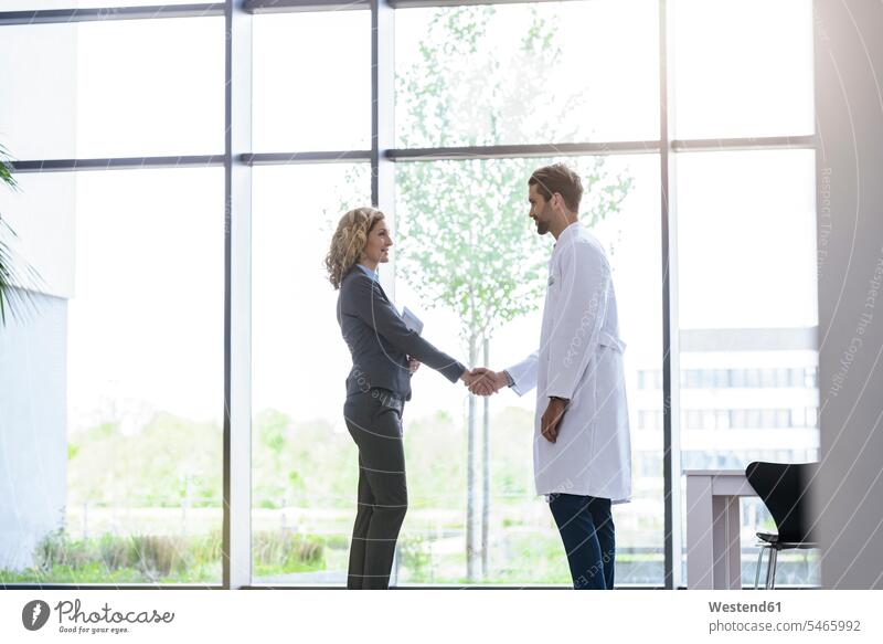 Geschäftsfrau und Arzt schütteln Hände im Krankenhaus Job Berufe Berufstätigkeit Beschäftigung Jobs geschäftlich Geschäftsleben Geschäftswelt Geschäftsperson