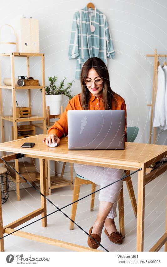 Zu Hause arbeitende Modedesignerin sitzt am Schreibtisch mit Laptop Leute Menschen People Person Personen Europäisch Kaukasier kaukasisch 1 Ein ein Mensch eine