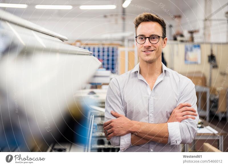 Porträt eines lächelnden jungen Geschäftsmannes in einer Fabrik Portrait Porträts Portraits Fabriken Zuversicht Zuversichtlich Selbstvertrauen selbstbewusst