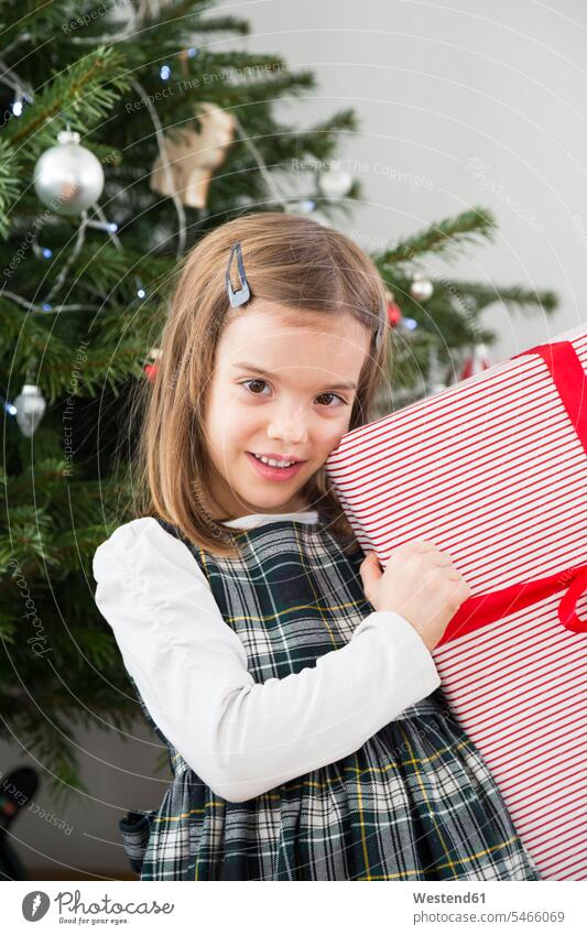 Porträt eines lächelnden kleinen Mädchens mit Weihnachtsgeschenk Portrait Porträts Portraits halten Weihnachtsgeschenke weiblich Geschenk schenken Geschenke