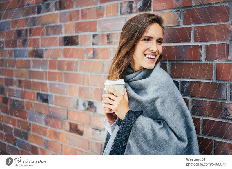 Porträt einer jungen Frau mit Kaffee zum Mitnehmen vor einer Ziegelmauer Portrait Porträts Portraits Backsteinwand Backsteinmauern Coffee to go zum mitnehmen