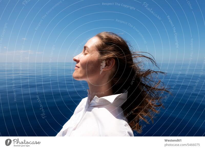 Seychellen, Indischer Ozean, Profil einer Frau auf einer Fähre, die die Brise genießt weiße Bluse Natur Meer Meere Touristin schön Wind Windstoß windig